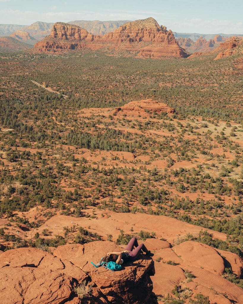 female hiker looking at sedona from the top of bell rock climb