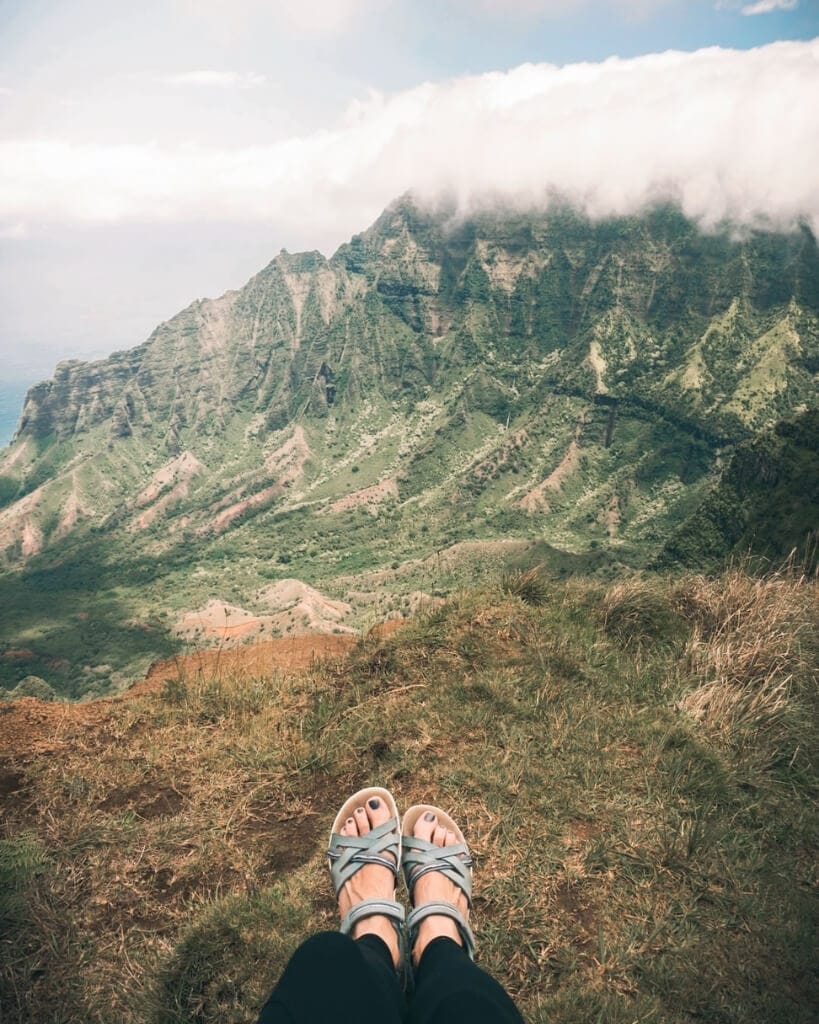 girl sitting on kalepa ridge in kauai hawaii