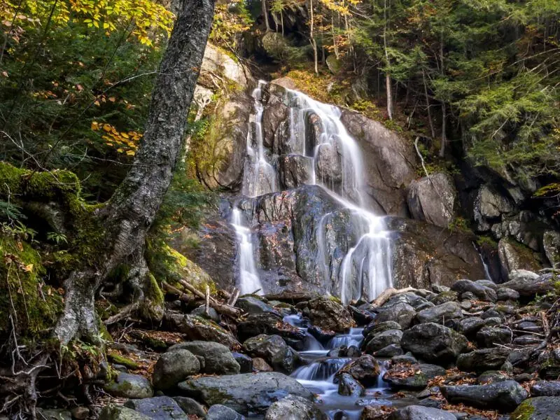 view of moss glen waterfall near stowe vermont in the fall