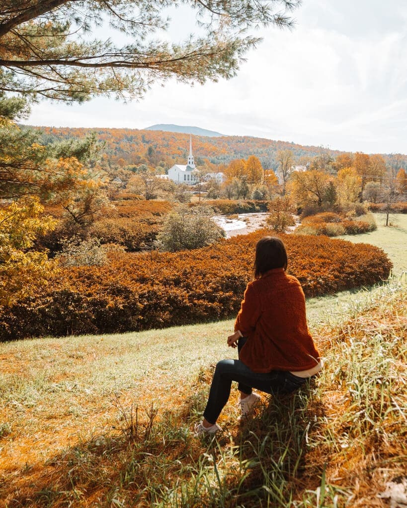 view of a girl wearing a fuzzy jacket, admiring stowe vermont in the fall